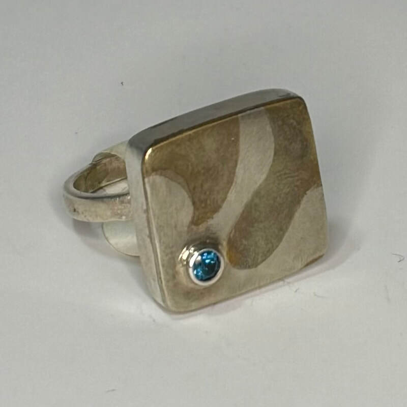 Marriage of metals. Sterling silver, copper, brass,nickel and a 4mm peridot. Size 8